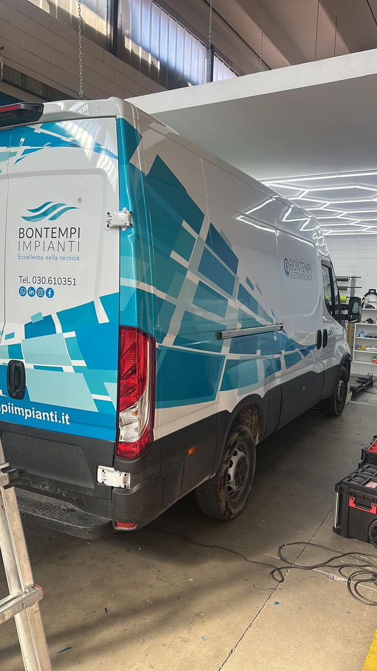 Furgone bianco Bontempi Impianti in officina, con grafica geometrica azzurra su fiancata e portelloni
