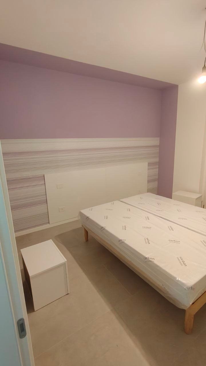 Camera da letto con rivestimento murale a righe e parete lilla