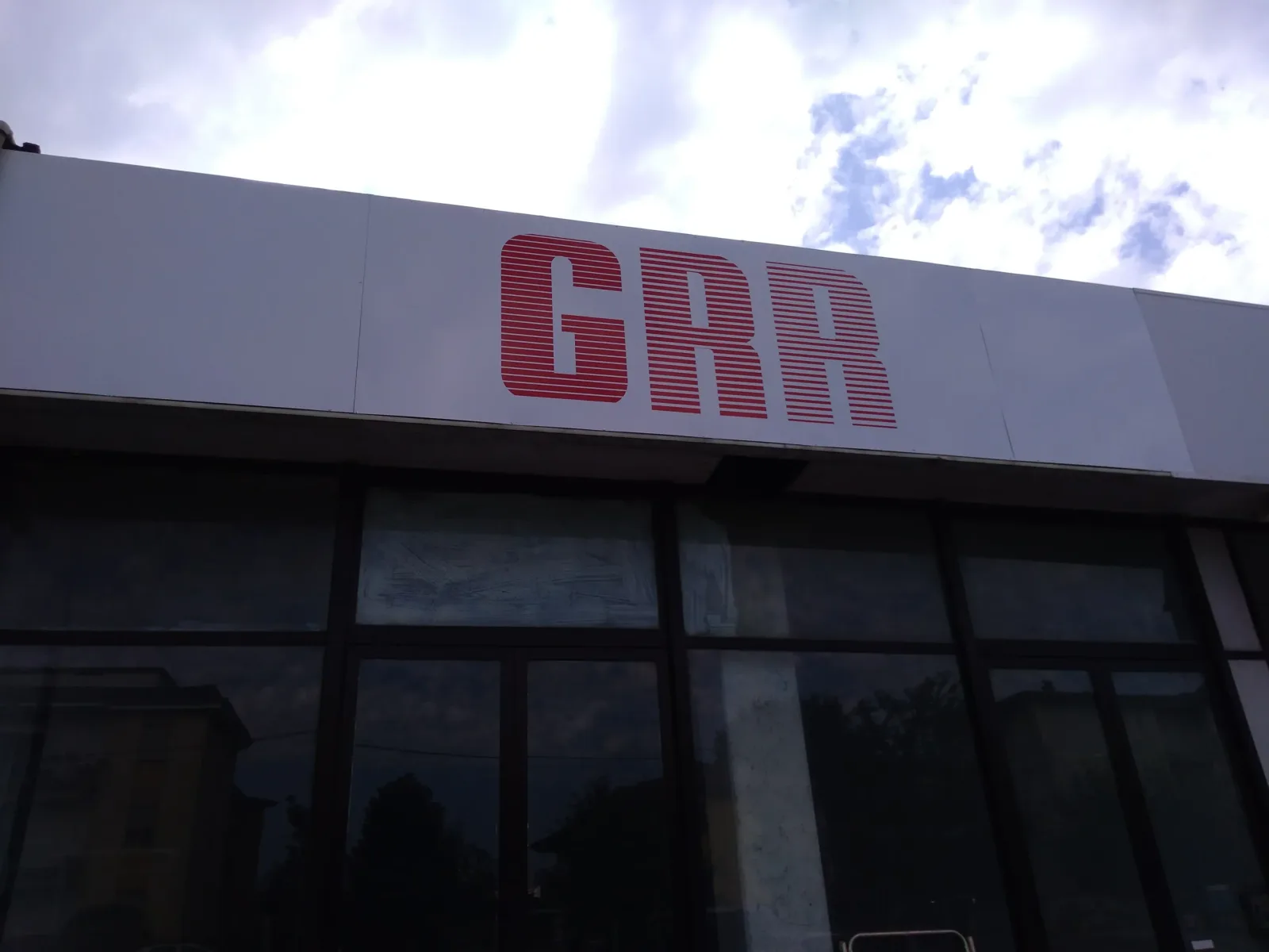 Insegna su pannello dibond con logo GRR rosso a righe sulla facciata di GRR Ricambi