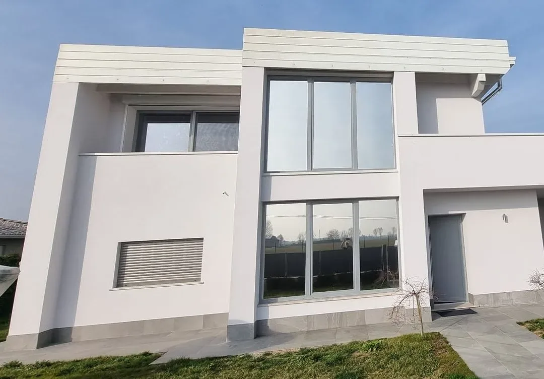 Villa moderna bianca con ampie finestre trattate con pellicola solare