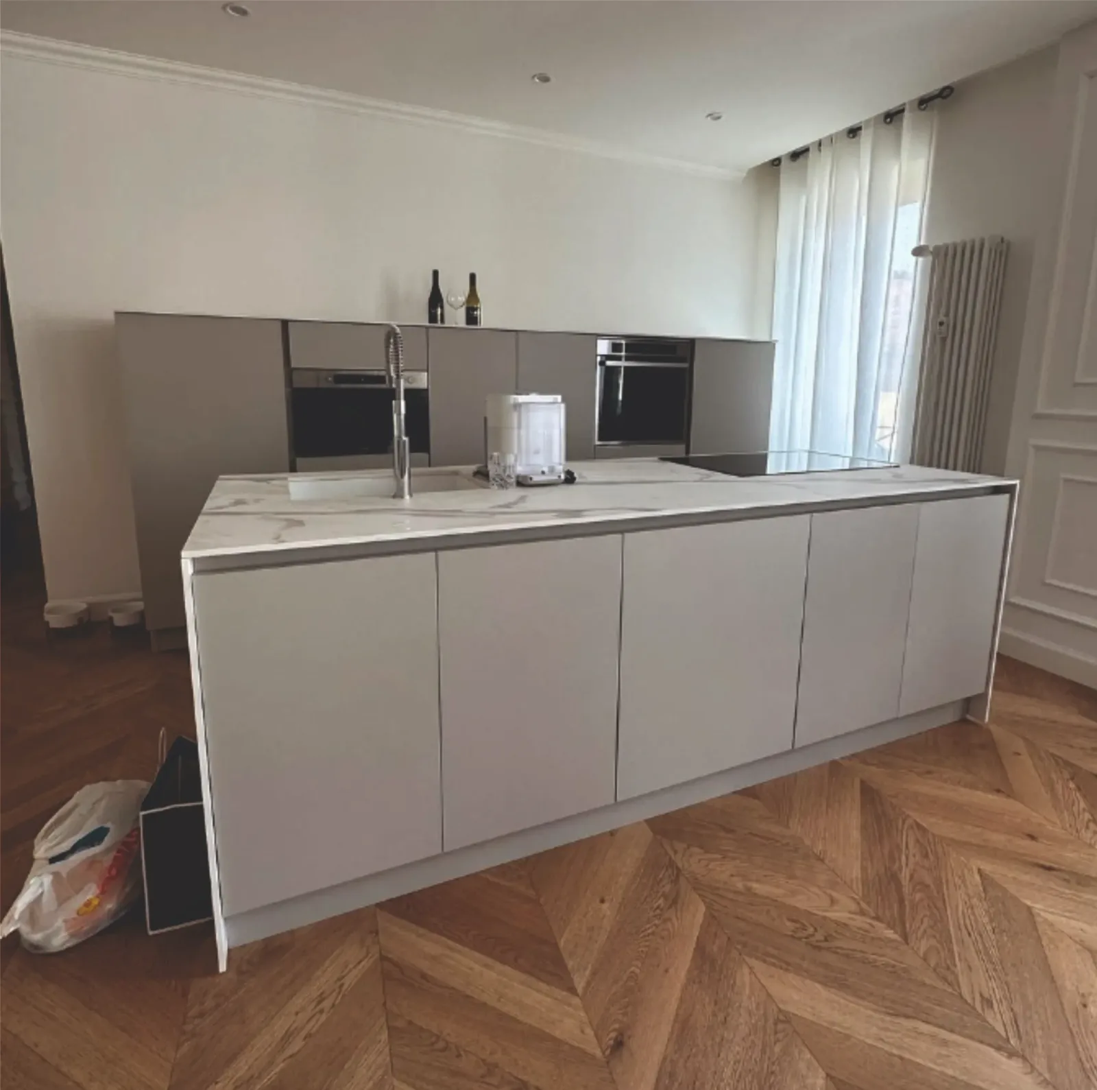 Cucina moderna con isola bianca e ante rivestite in pellicola