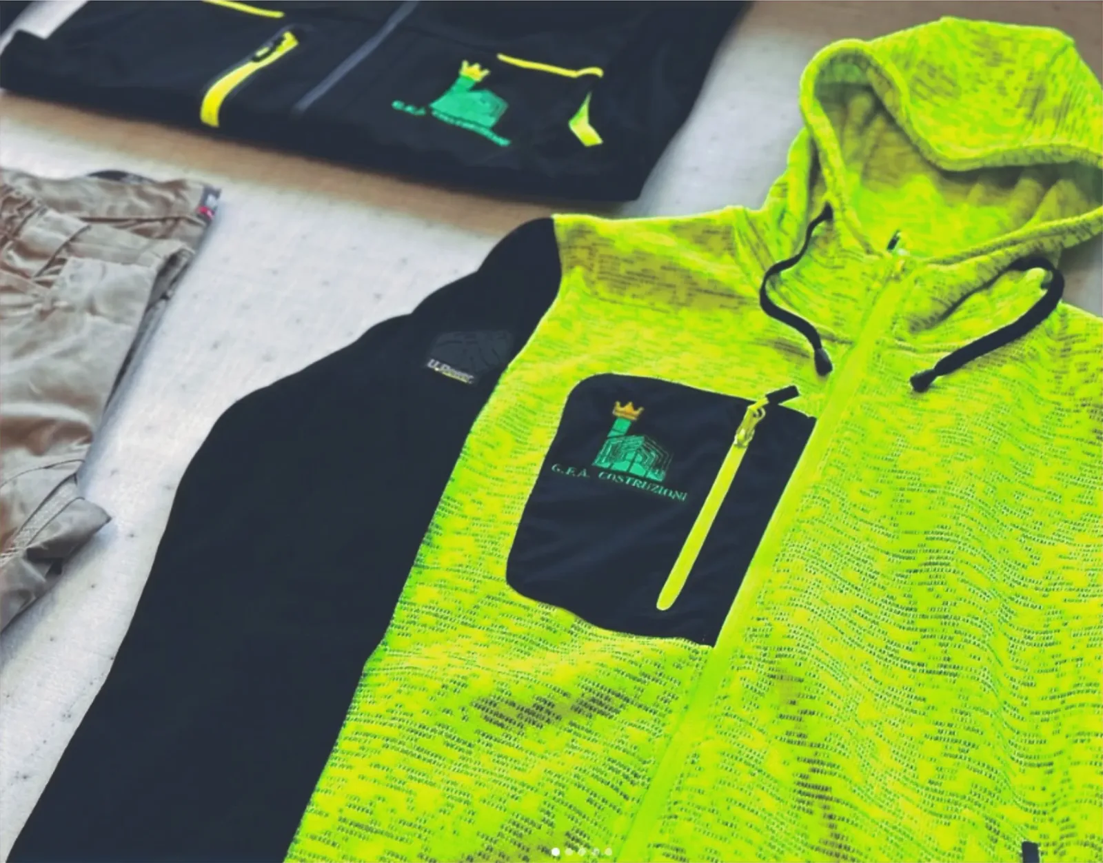 Giacche softshell fluo e nere con logo ricamato G.E.A. Costruzioni